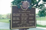 A historical marker plaque titled 'The Abolition Editors' featuring a list of names and details related to abolitionist editors, set against a green landscape.