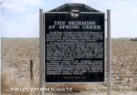 Historic marker titled 'The Skirmish at Spring Creek' in a field, providing information about the skirmish.