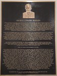 A bronze plaque featuring a bust image at the top and a detailed inscription about George Edward Warden, highlighting his life achievements and contributions.